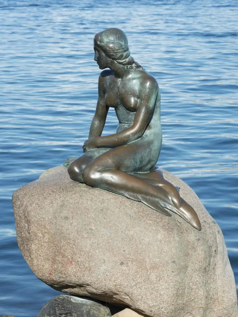 Bronze sculpture of the Little Mermaid sitting on a rock at Langelinie promenade, Inner Harbour, Copenhagen, Denmark