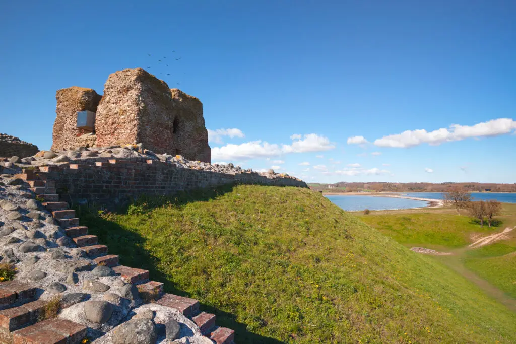 Historic Kalø Castle ruins overlooking the scenic coastline at Mols Bjerge National Park, Denmark, highlighting a popular Danish tourist attraction.