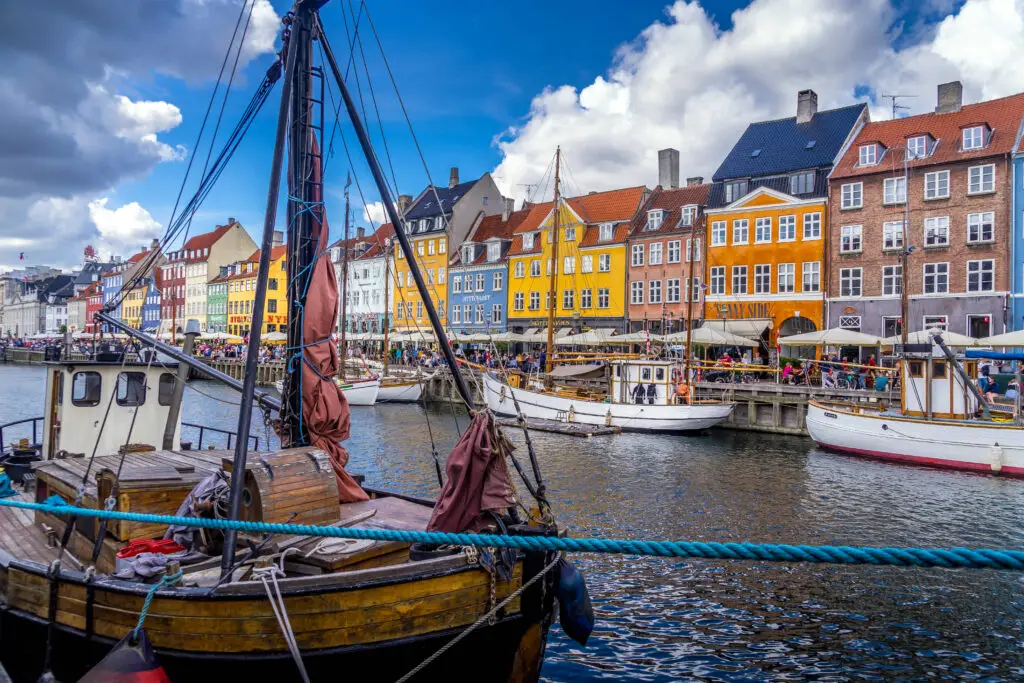 View of colorful buildings and boats along the canal in Nyhavn, Copenhagen, a popular tourist destination in Denmark
