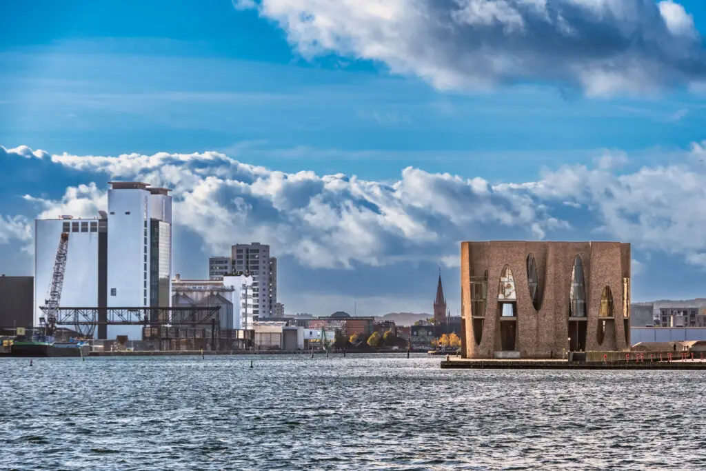 Picturesque view of Vejle harbor front featuring the architectural marvel Fjordenhus on a sunny day, Denmark
