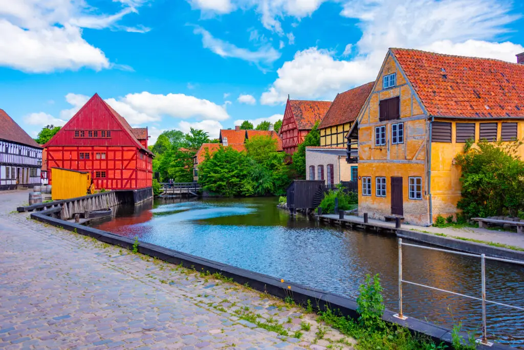 Vibrant traditional Danish houses around the canal at Den Gamle By museum, Aarhus, Denmark, perfect for cultural tourism.