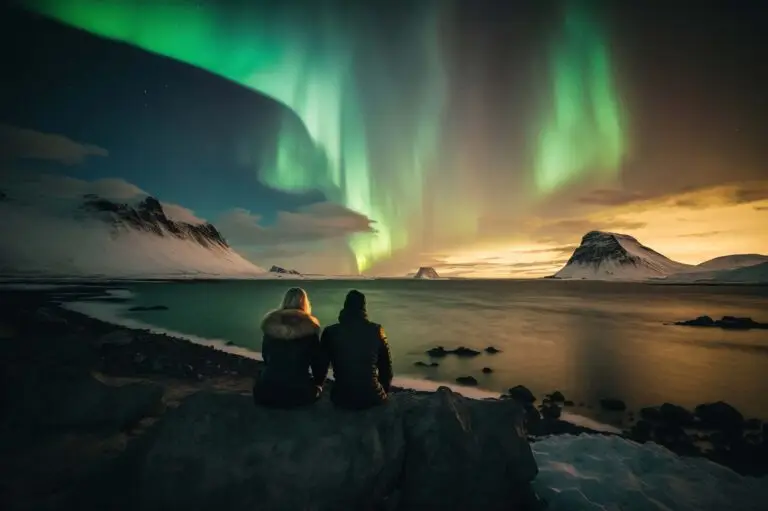 Couple watching the Northern Lights over a snowy Norwegian landscape, perfect for a custom tour in Norway.