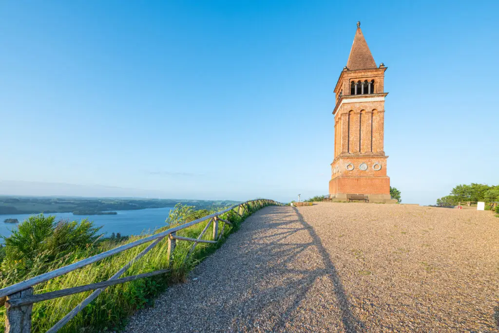 Himmelbjerget tower overlooking serene lake in Denmark, a popular Scandinavian tourist attraction perfect for history and nature enthusiasts.