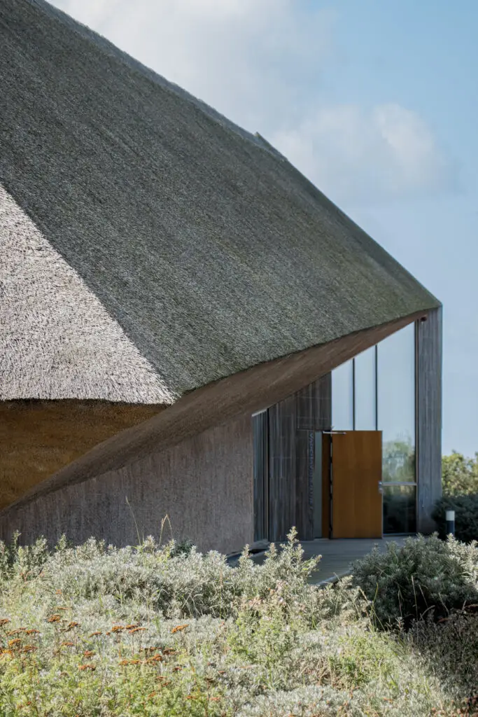 Unique architecture of Vadehavscentret, the Wadden Sea Center in Ribe, Denmark, showing modern design with traditional thatched roof and natural surroundings.